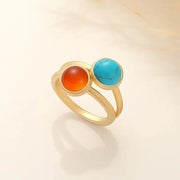 14k Gold filled ring with red carnelian and blue turqouise gemstones on a beige background