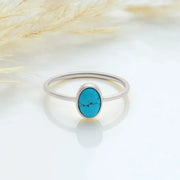 Sterling silver ring with an oval turquoise stone on a light background
