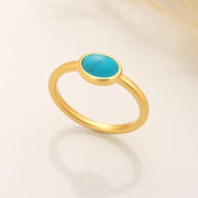 14k Gold filled ring with a turquoise stone on a light beige background