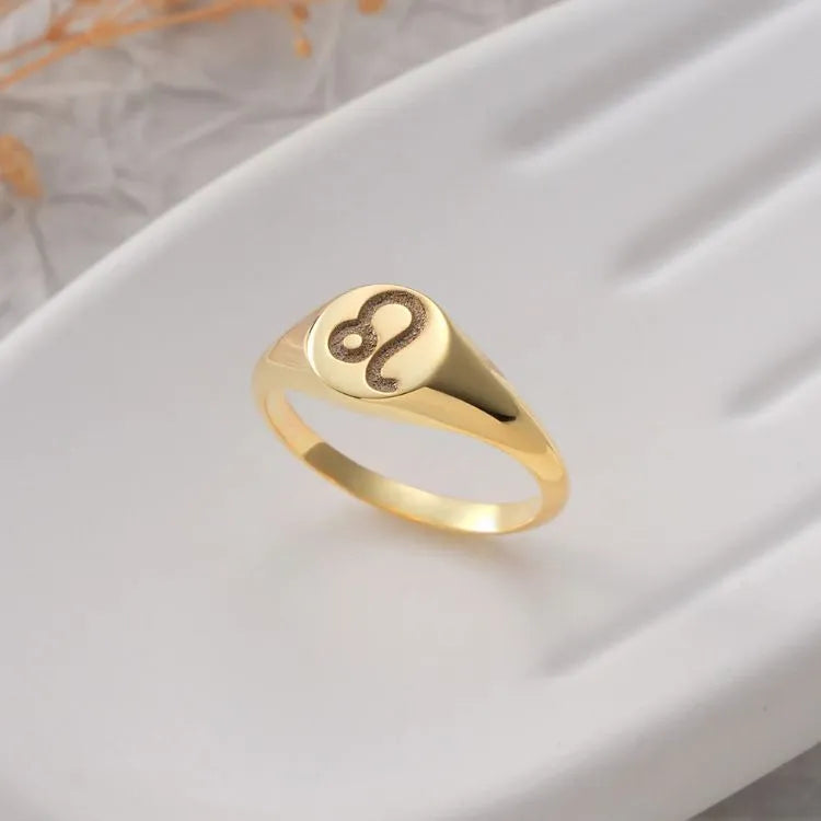 14k Gold filled signet ring with a zodiac symbol on a white surface