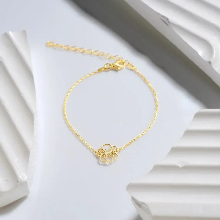 14k Gold filled bracelet with a birth flower charm on a white surface