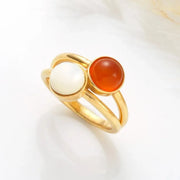 14k Gold filled ring with two colored natural gemstones (moon stone and carnelian) on a light background