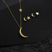 14k Gold necklace with moon and star pendants on a black textured background
