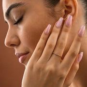 Model is wearing 14k gold filled ring with purple gemstones and a five-petal flower design