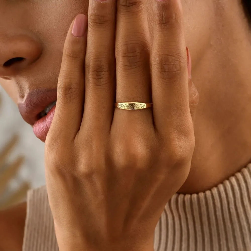 Model is wearing a birth flower engraved  band ring