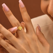 14k Gold filled ring with a letter 'S' on a person's finger against a brown background