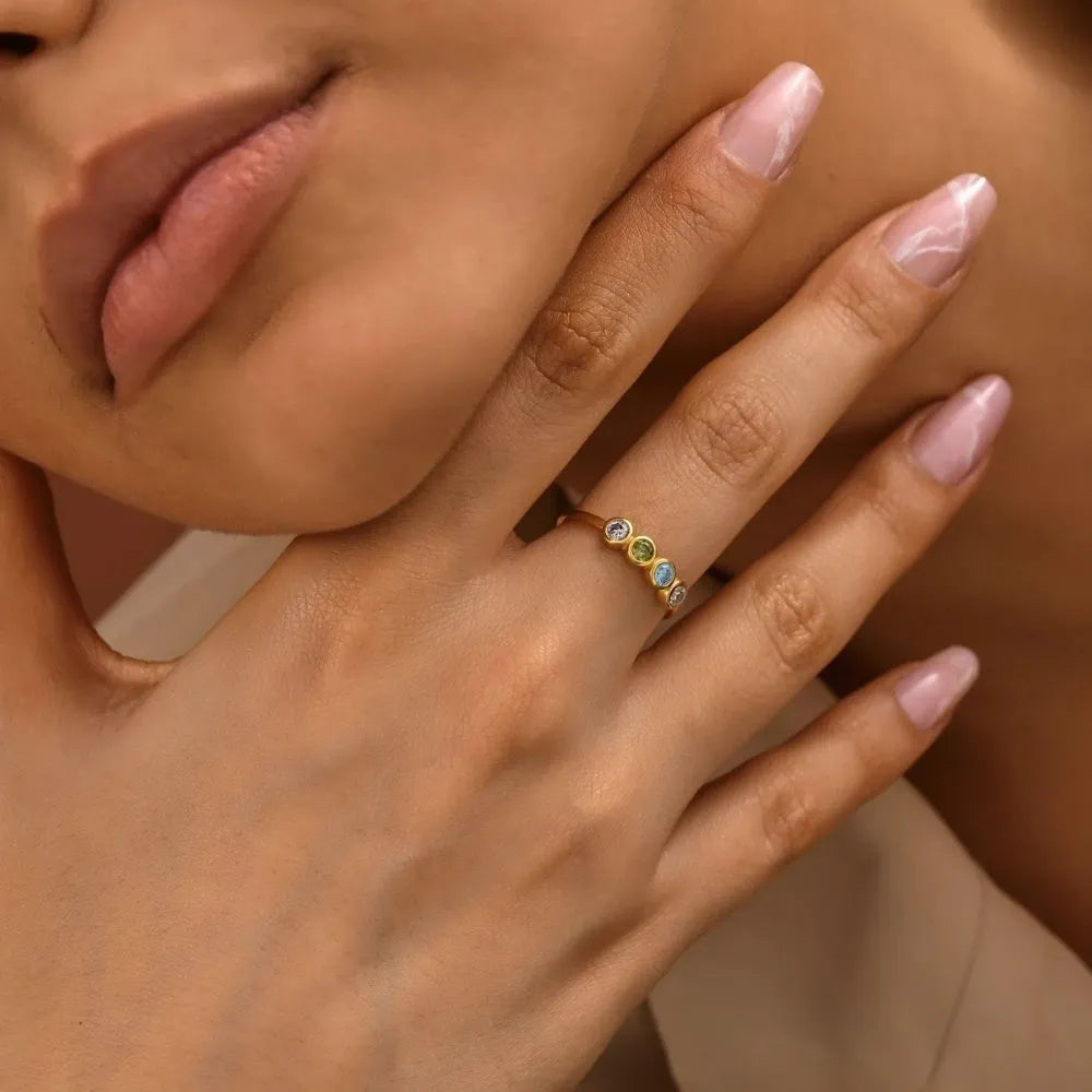 The model is wearing a 14k gold-filled round birthstones ring.