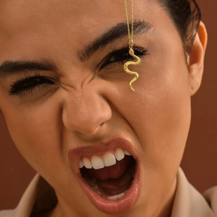 Close-up of a woman with a 14k gold filled snake necklace.
