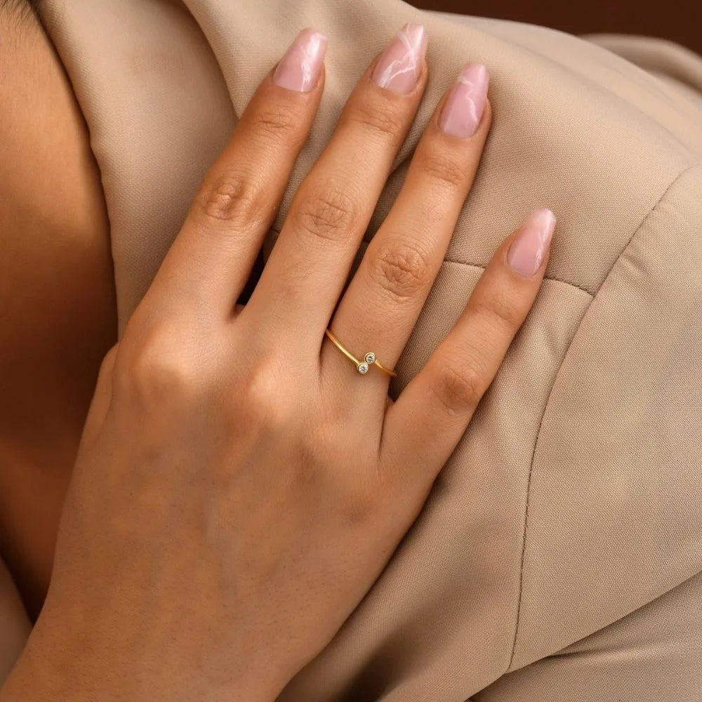 The model is wearing a dual birthstone ring