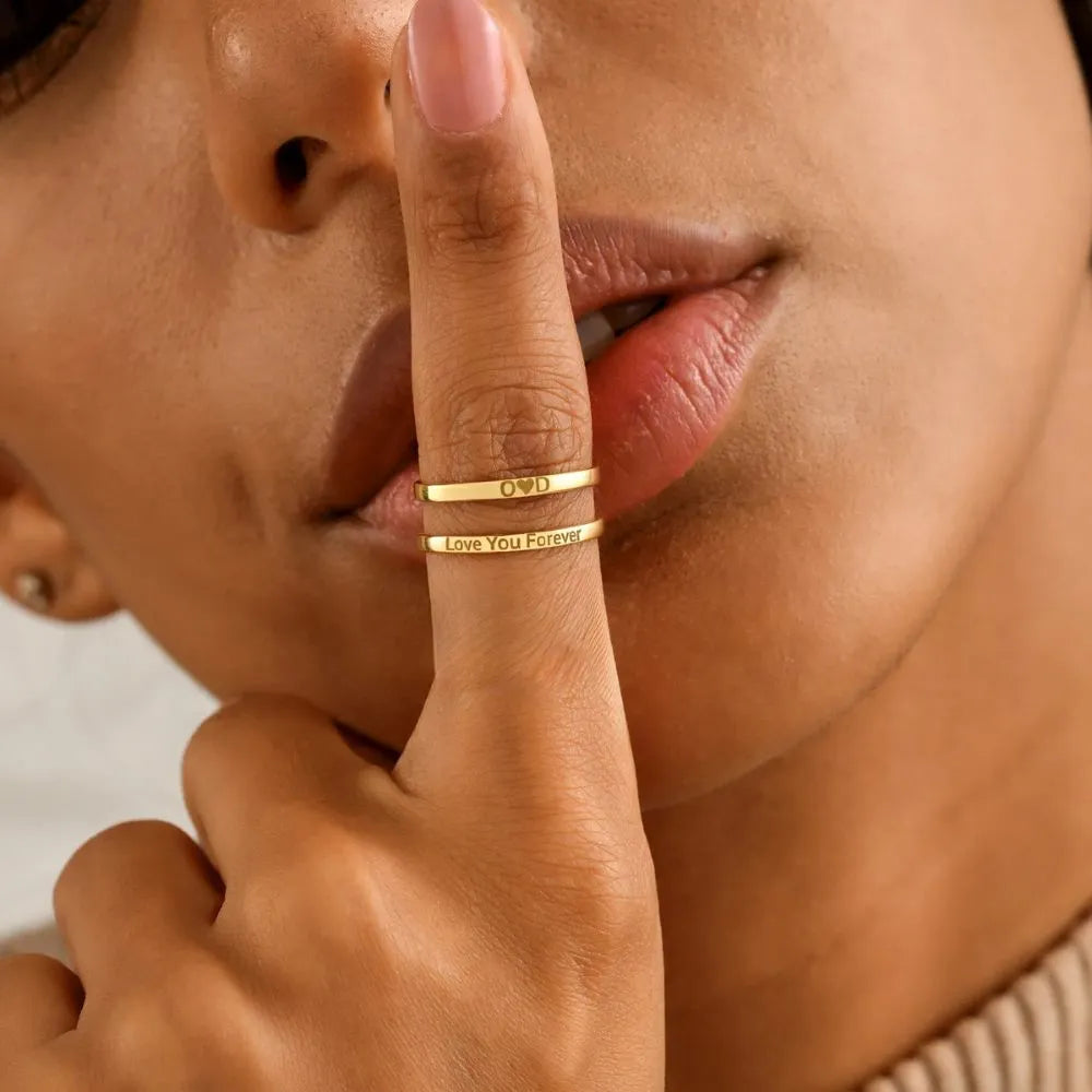 Close-up of a woman's hand with a 14k gold-filled ring on her finger, touching her lips.