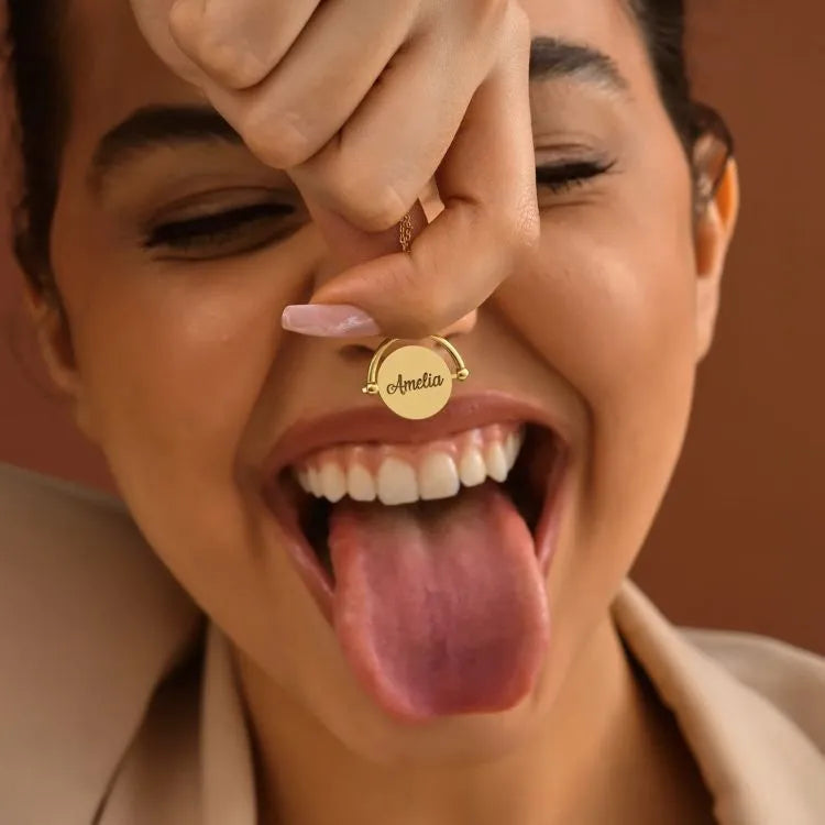 Person wearing a 14k gold-filled necklace with a pendant, sticking out their tongue.