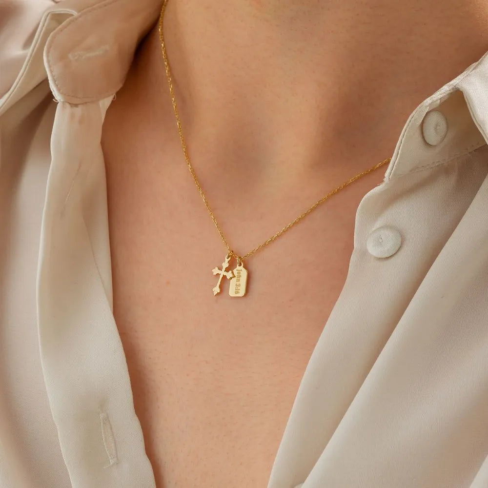 14k Gold necklace with cross and vertical bar pendant worn by a person in a light-colored shirt.