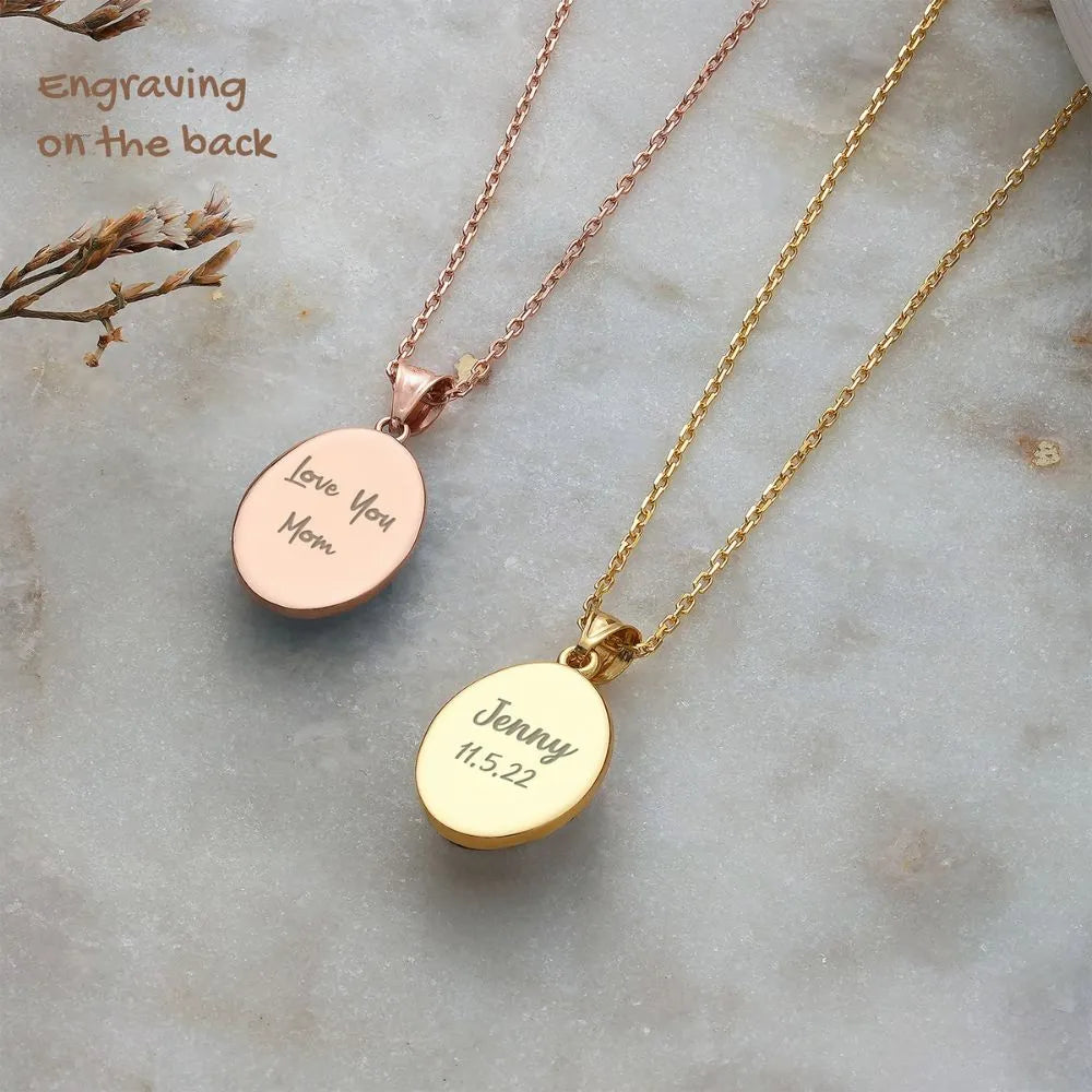 Two 14k gold carnelian necklaces with engraved messages on a marble surface.