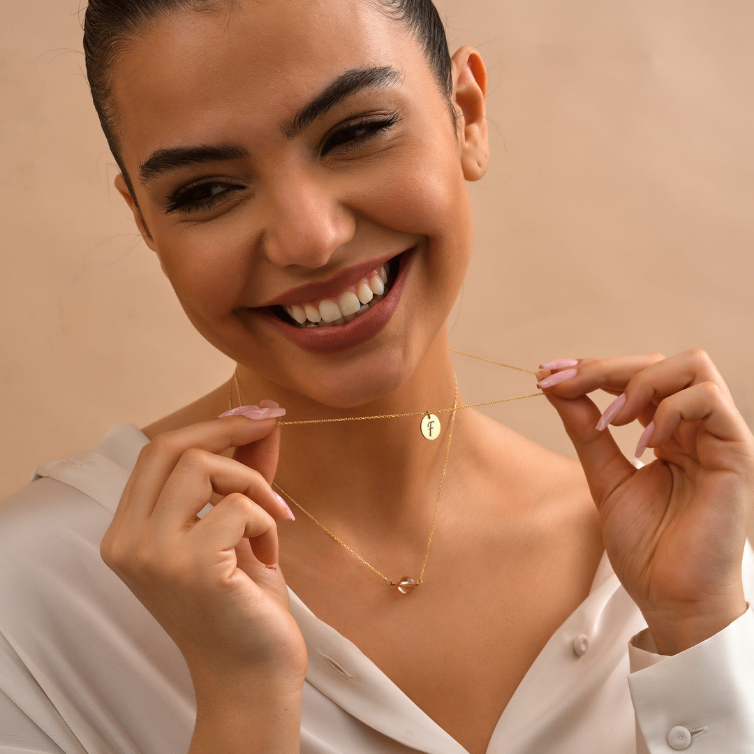 Woman Wearing Layered Disc Initial Necklace with Birthstone – Elegant Personalized Jewelry by Lyphiyes