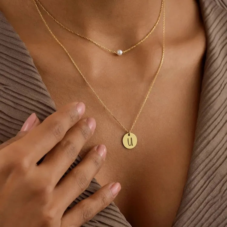 Woman model wearing 14k gold filled pearl disc layer necklace.