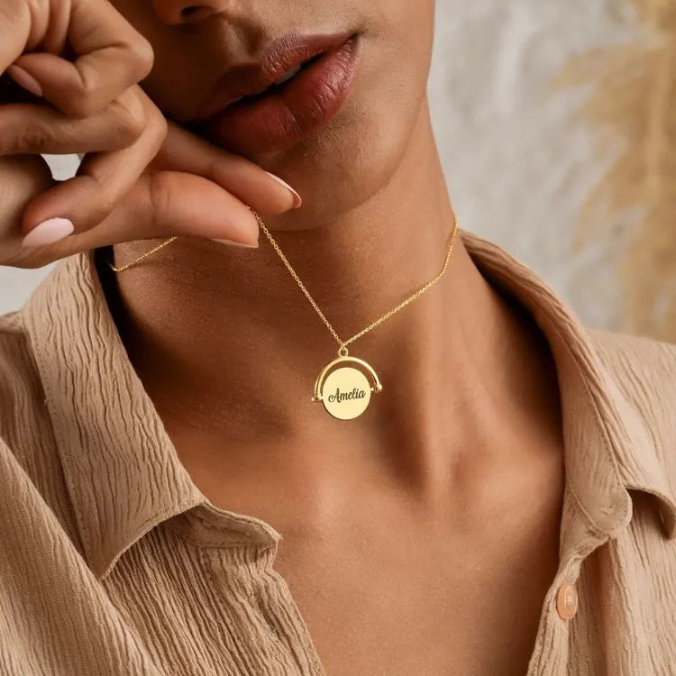 Woman wearing a 14k gold-filled spinner pendant necklace with a round pendant, set against a neutral background.