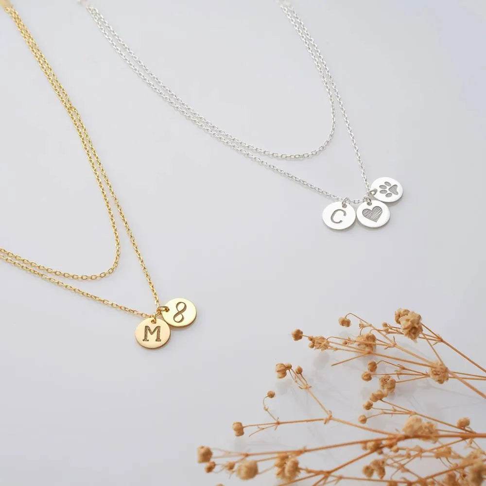 Two necklaces with small pendants on a light background with dried flowers.
Necklace materials:
925 sterling silver, and 14k gold-filled.