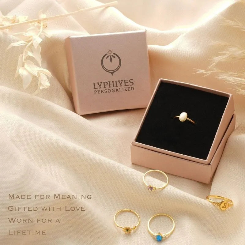 Jewelry presentation image featuring rings arranged on fabric with branded packaging
