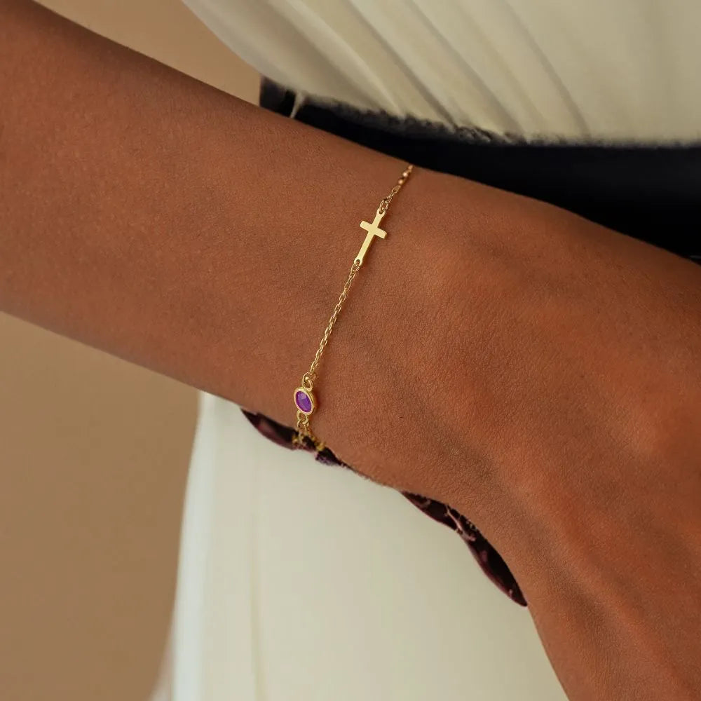 14k Gold bracelet with a purple Amethyst gemstone on a wrist against a neutral background