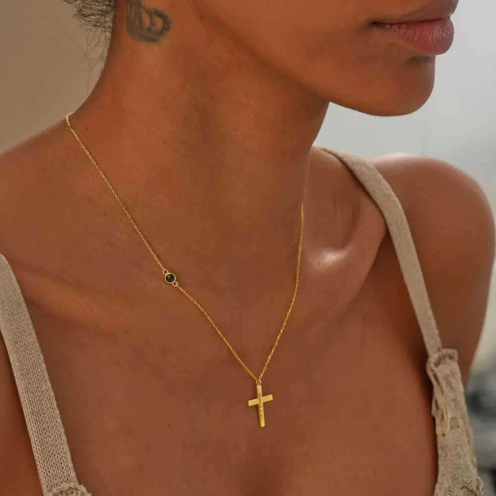 Woman model is wearing a 14k gold necklace with a cross pendant.