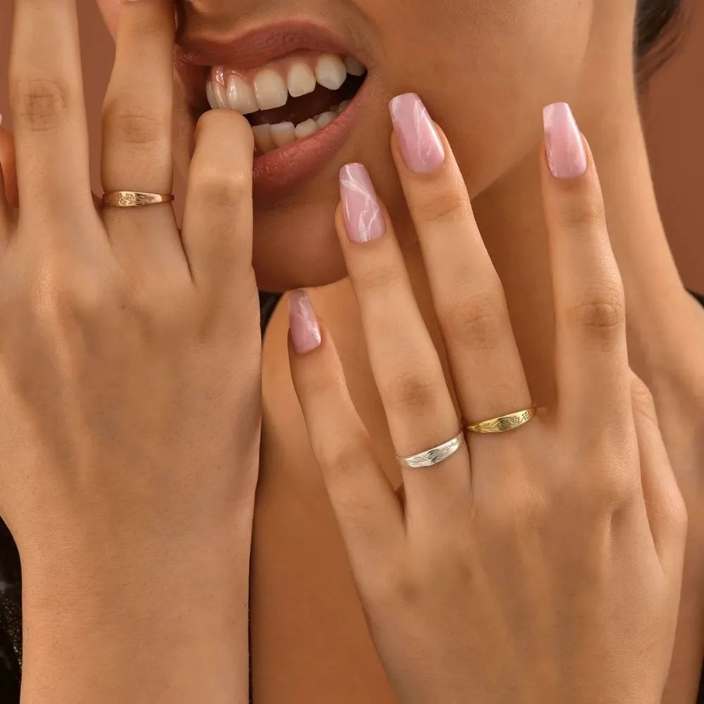 Model is wearing engraved birth flower band rings