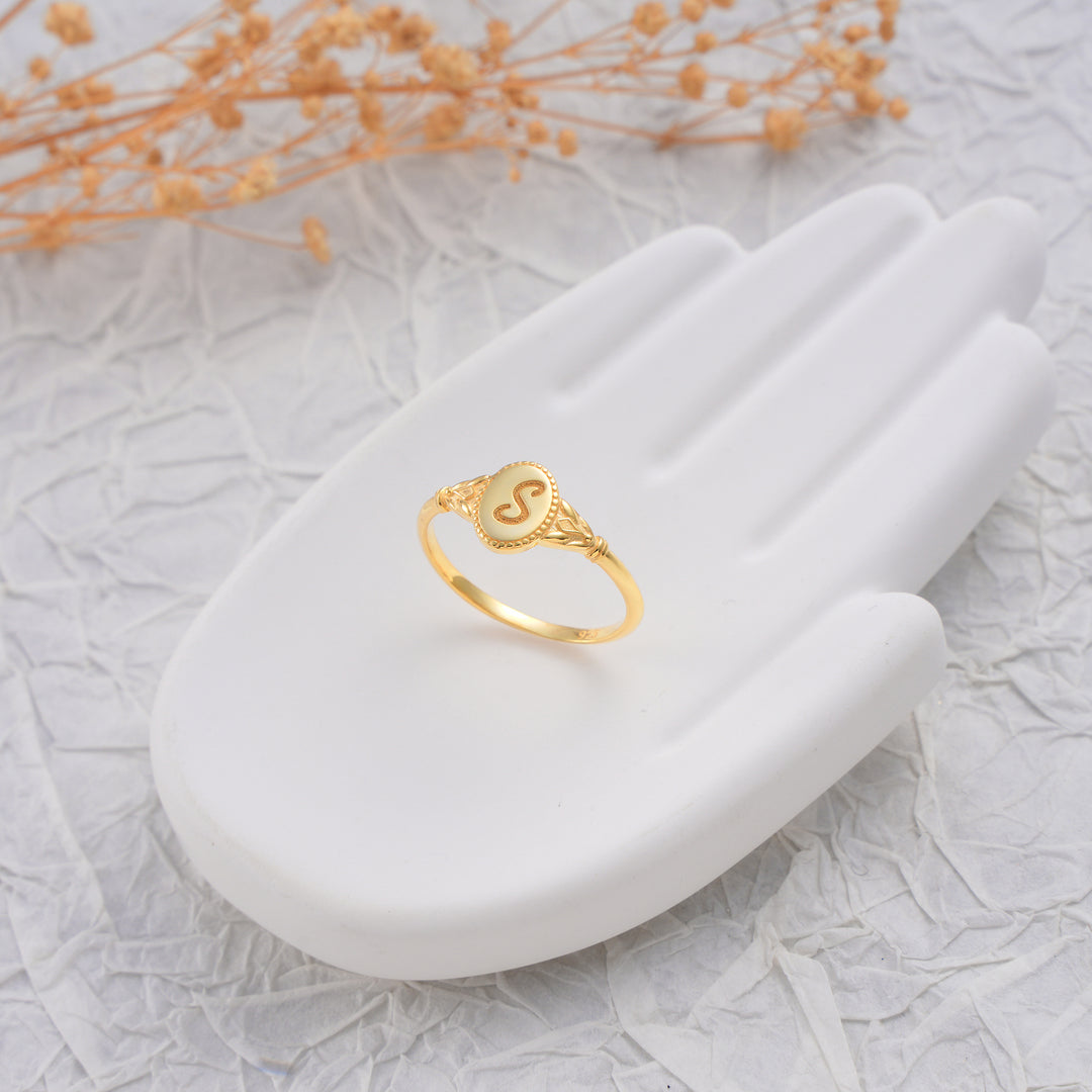 Gold ring on a white stone surface with a light background