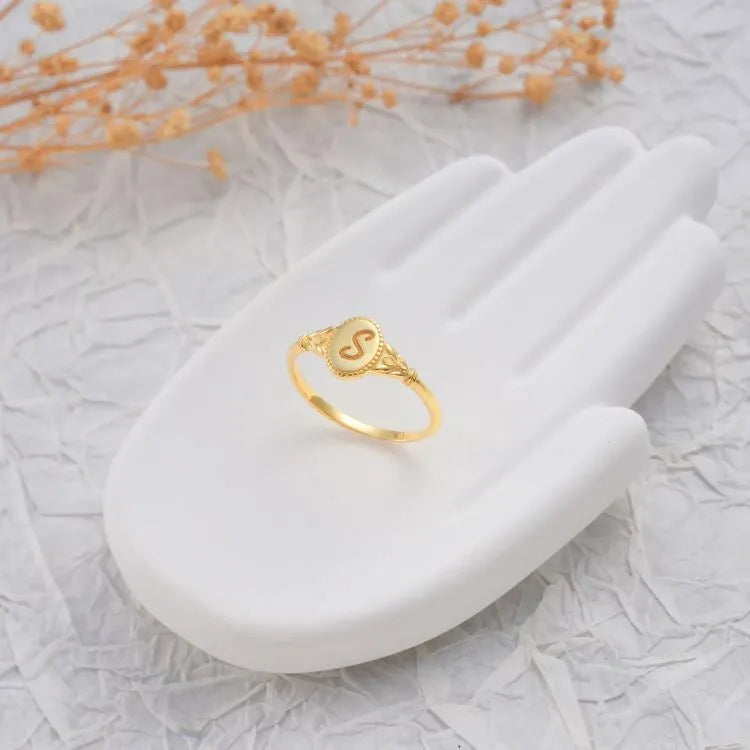 14k Gold filled initial signet ring on a white stone surface with a light background