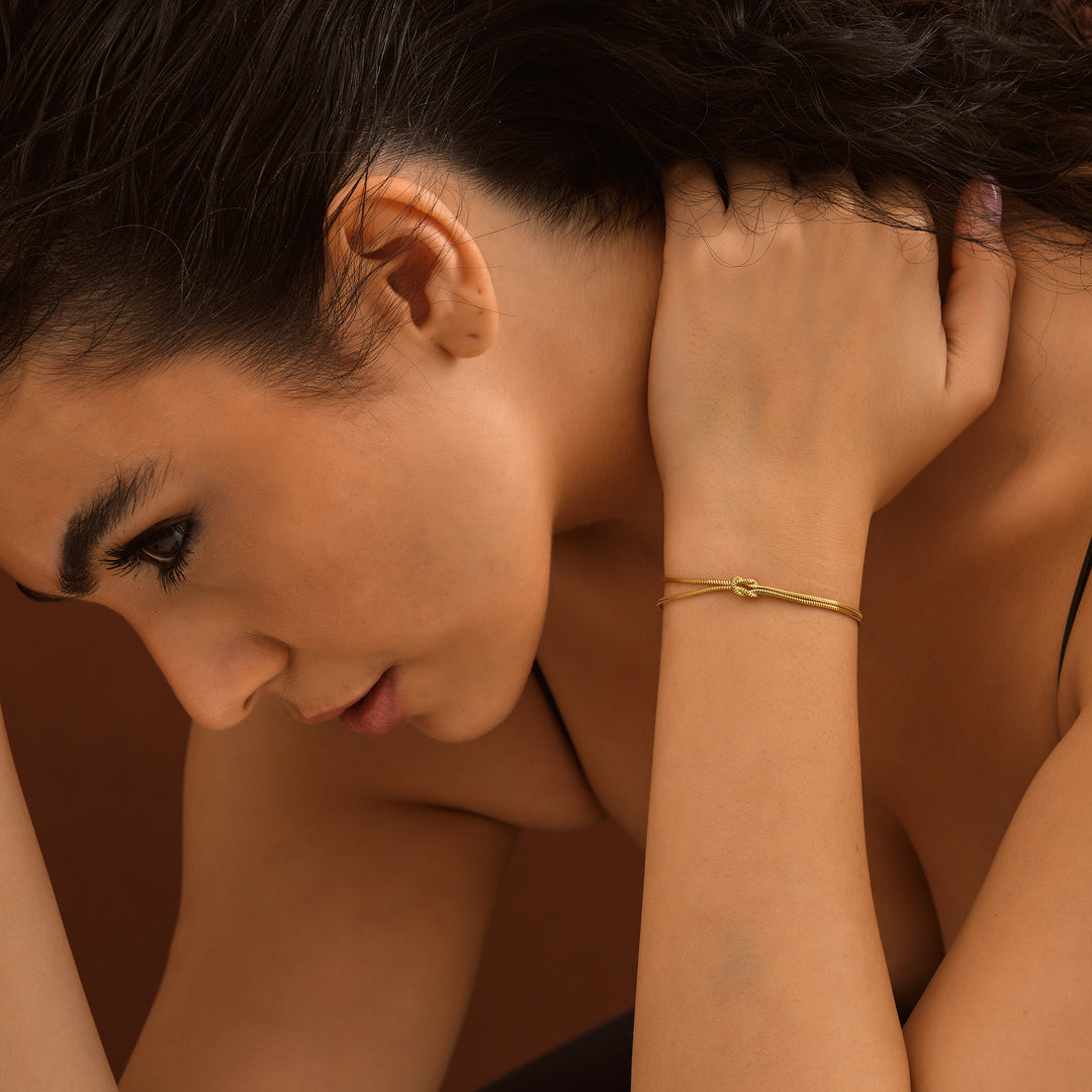Woman with hand on head against a brown background